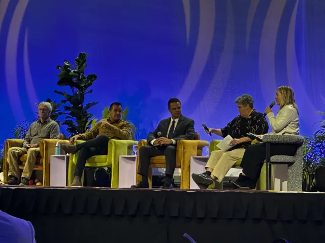 Five people seated on stage