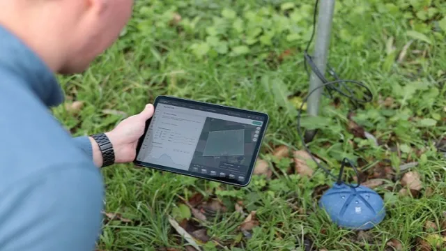 Person holds a tablet with a view of a farm management system featuring patented spiral-design soil sensors and ET monitoring