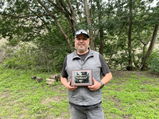 Image of Augustin Aguilar holding his Nature Champion award for his work on the installation of Elkus Ranch's Compost Project.