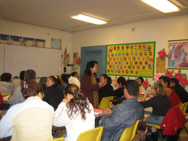 Lan stands in middle of people sitting at desks