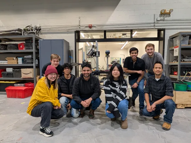 The Fire Blighters team of Carnegie Mellon University crouch in a workshop setting
