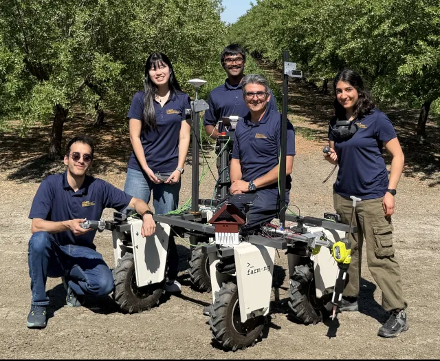 Aggie Aerial-Ground Robotics team of UC Davis pose by their Amiga robot platform in an orchard