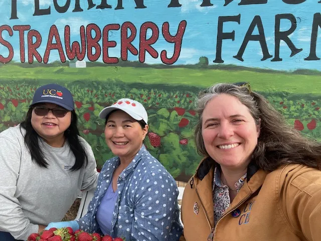 From left to right, Fam Lee, farmer Muang and Margaret Lloyd pose for a selfie in front the Florin Fresh Strawberry Farm sign