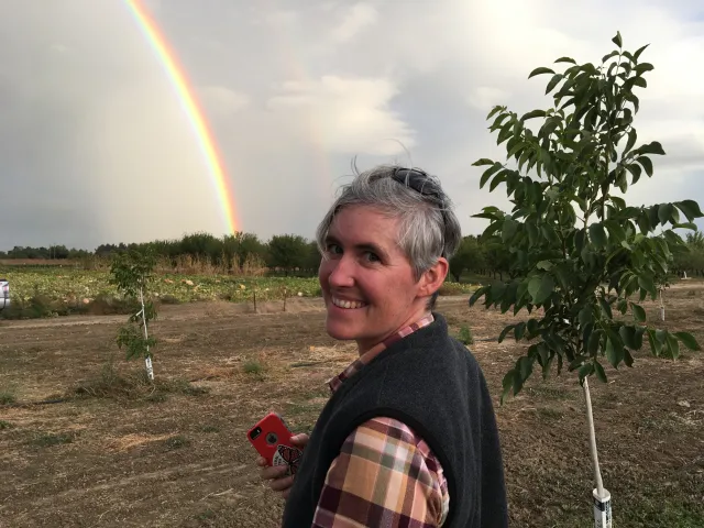 Cassandra Swett smiling with a rainbow in the background