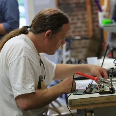 Side view of Steve as he works on a computer board at a desk