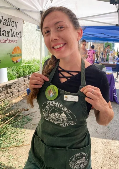 Ary West works at the farmers market while showing off her Cedarville Farmers Market apron