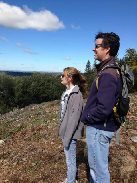 A man and young woman stand out on a hilltop.