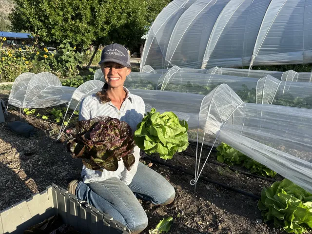 Leah Larsen of Bidwell Canyon Farm beams while showing off her head lettuce