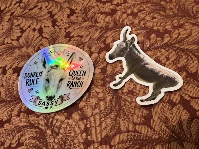 Two stickers: a circle with a picture of Sassy reads, "Donkeys rule. Sassy Queen of the Ranch" and a full body photo of Sassy.