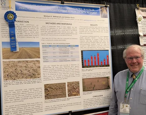 Michael stands beside his cutworm poster