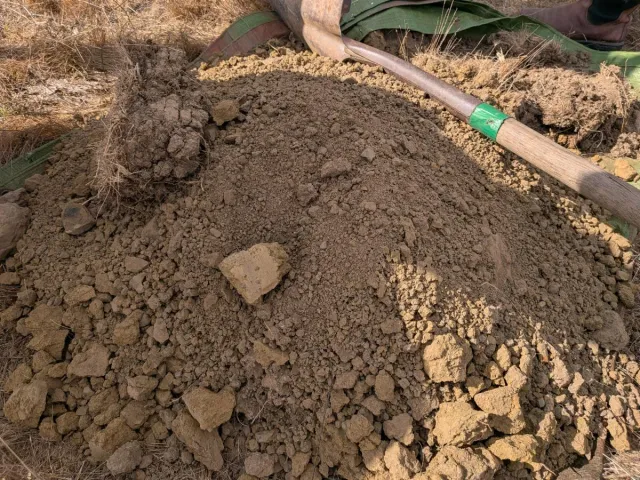 Pile of soil with a shovel.