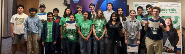 4-H youth standing in rows holding certificates