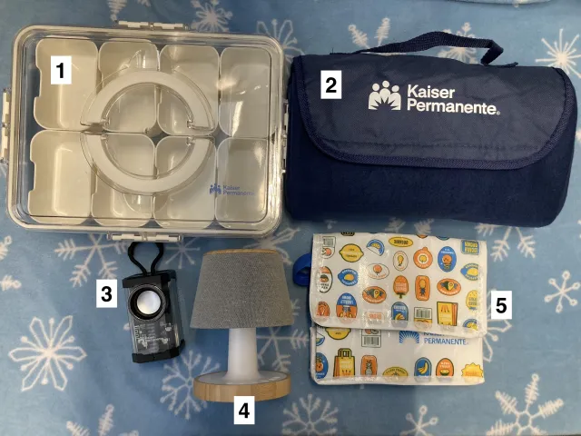 Health for the Holidays prizes. The snackle box has eight compartments and is about a foot long. The insulated lunch cooler is soft-walled and folds up small. The travel speaker is four inches tall. The small lamp's lampshade is a Bluetooth speaker.