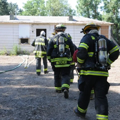 GOING IN--UC Davis firefighters rush into the Baxter House for a control burn, part of a training exercise led by assistant chief Nathan Trauernicht. (Photo by Kathy Keatley Garvey)