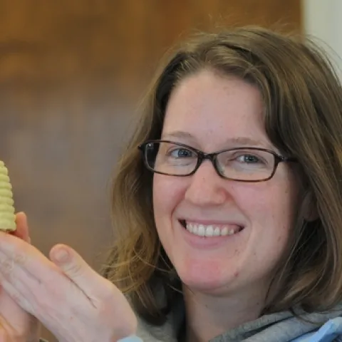 BEEKEEPER Elizabeth Frost shows a miniature beehive candle she made from beeswax and a little paraffin. (Photo by Kathy Keatley Garvey)