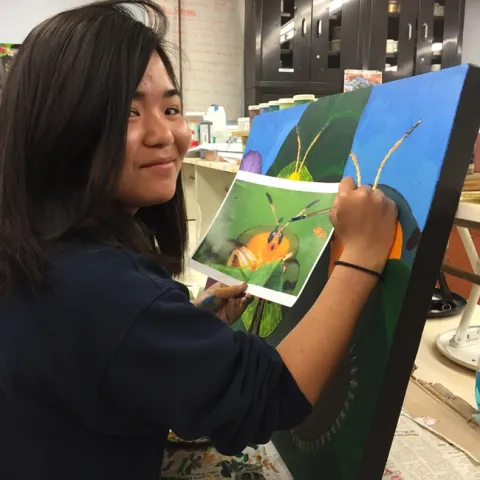UC Davis student Kelly Aoyama works on a painting that will be displayed June 3 at a public art exhibit in Davis. (Photo by Diane Ullman)