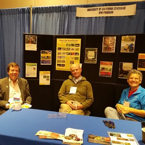 Lifetime achievement award winners Frank Zalom (left) and Pete Goodell share a moment in the UC IPM booth with Cheryl Wilen, Area IPM Advisor and IPM Extension Coordinator for Natural Resources. (Photo by Lena McBean, Remsberg Inc.)
