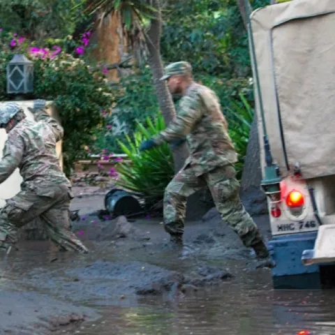 California National Guard members wade through mud to people trapped inside a Montecito home. Air National Guard photo by Senior Airman C. Housman.