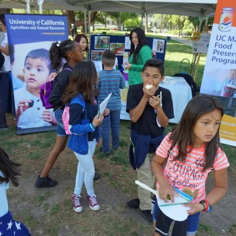 UC ANR's EFNEP program staffed a booth along with the UC Master Food Preserver Program at the Million Meals Summer picnic for Sacramento youth.