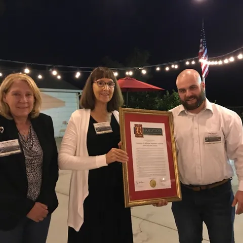 In recognition of UCCE Sutter-Yuba's centennial, Janine Hasey, center, was presented a Senate/Assembly Resolution by Laura Nicholson, senior district representative for state Senator Jim Nielsen, and Joe Brennan, who represented Assemblymember James Gallagher.