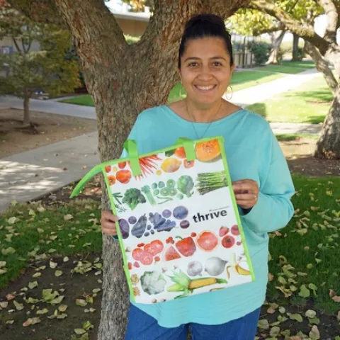 The Staff Assembly Ambassador for the Kearney Agricultural Research and Extension Center, Emily Casado, shows the insulated bag that the first 100 registrants to the UC ANR Maintain Don't Gain Challenge will receive.