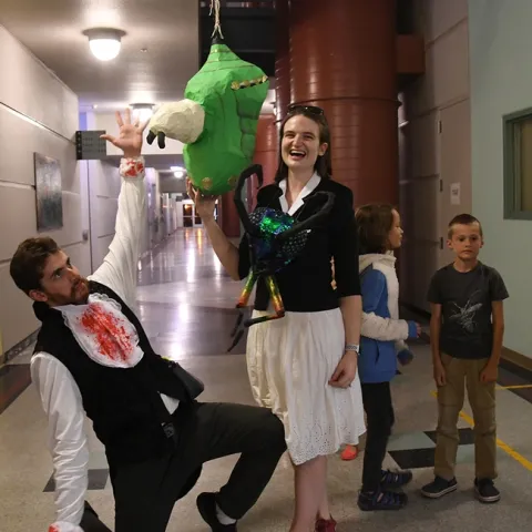 Two co-creators of the monarch chrysalis piñata--Charlotte Herbert Alberts and husband George Alberts--pose with the piñata just before the start of the game. (Photo by Kathy Keatley Garvey)