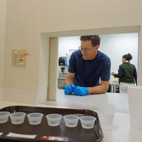USDA technician Paul Neipp presents a tray for lemon water tasting in one of the sensory lab booths.