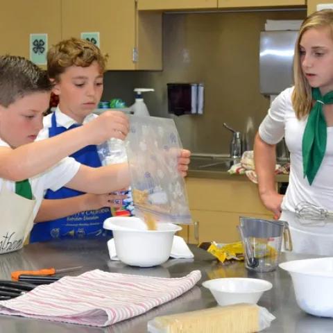 Elisabeth Watkins, right, winner of the 2019 4-H Youth in Action Award for Healthy Living, mentoring younger 4-H members on a cooking project.