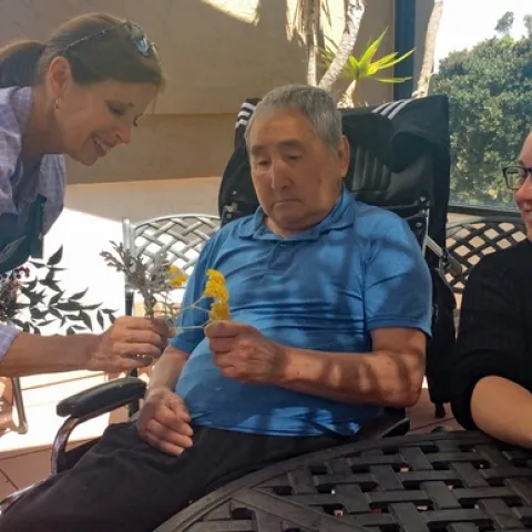 A workshop participant was invited to explore all senses of gardening, with flowers, seed packets and garden tools. (Photo: Debbie Handal)
