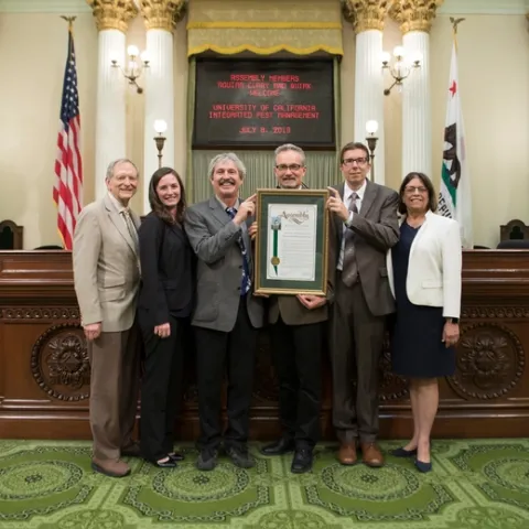Assemblymembers Cecilia Aguiar-Curry and Bill Quirk presented Jim Farrar with a proclamation honoring UC IPM at the Capitol. From left, Quirk, Anne Megaro, Mark Bell, Farrar, Mark Lagrimini and Aguiar-Curry.