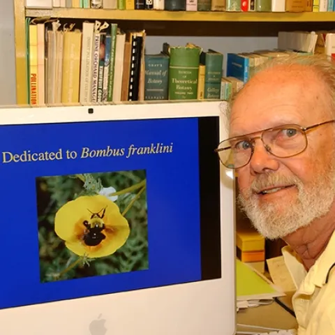 Robbin Thorp, distinguished emeritus professor of entomology at UC Davis, with his screensaver, an image he took of Franklin's bumble bee. He passed June 7. (Photo by Kathy Keatley Garvey)