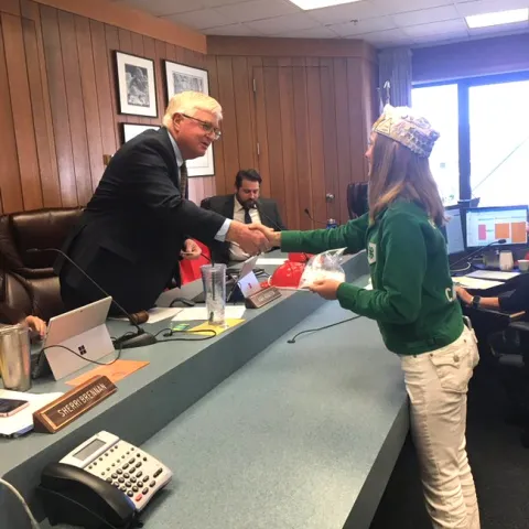 Board Chair, Supervisor Karl Rodefer shaking the hand of Belle, Tuolumne County Ambassador