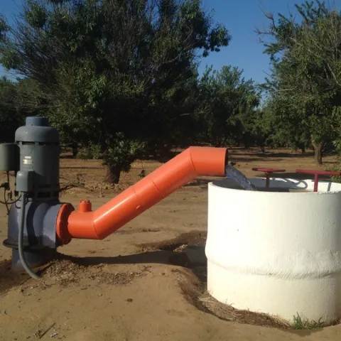 Groundwater is drawn by a pump to irrigate almonds in Fresno County.