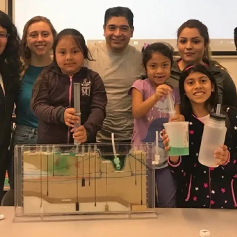 Dr. Sam Sandoval (center) shows afterschool program youth a groundwater model. Photo by Jose Huerta.