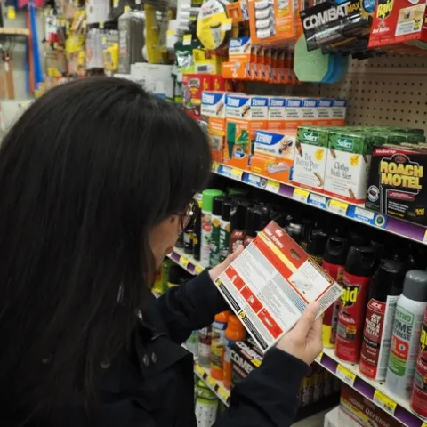 Person reads a pesticide label in the retail aisle.
