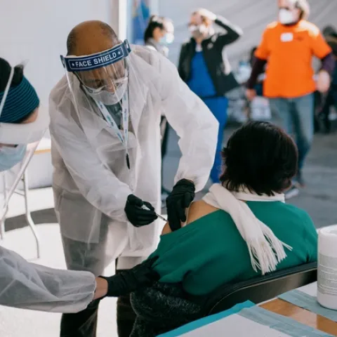 President Drake vaccinates an individual in the Bay Area's Mission District.