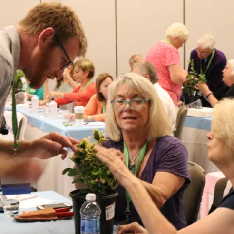 Attendees at a UC Master Gardener traiing looking at a plant