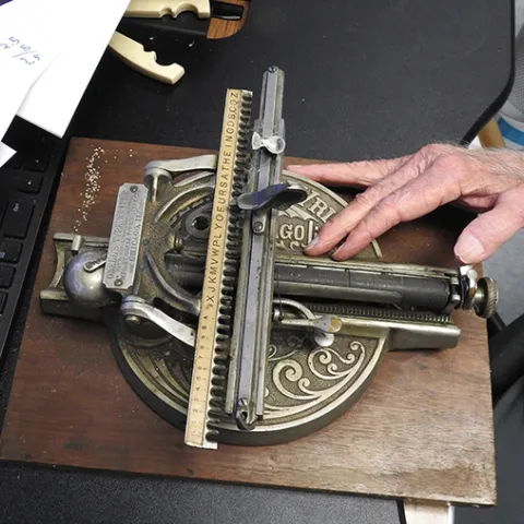 A hand of UC Davis distinguished professor Bruce Hammock rests on the Odell "type writer." (Photo by Kathy Keatley Garvey)