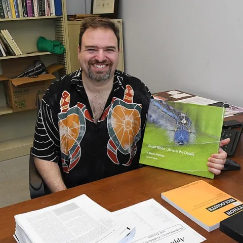 Medical entomologist-geneticist Geoffrey Attardo, shown with his book of macro images, is the winner of the Medical, Urban and Veterinary Entomology Award from the the Pacific Branch, Entomological Society of America.