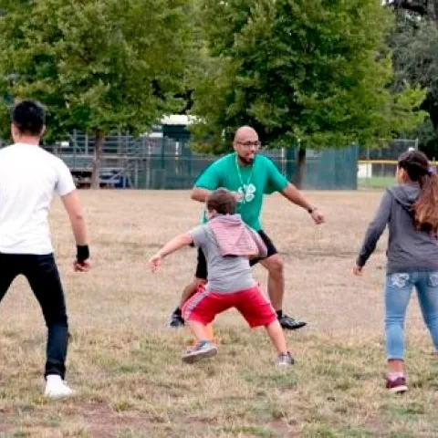 Kids exercise outdoors with an instructor