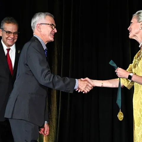 UC Davis distinguished professor Walter Leal, inducted as a Fellow of the National Academy of Inventors, receives congratulations from the NAI's Elizabeth Lea Dougherty, J.D., director of Inventor Education, Outreach, and Recognition in the Office of Innovation Development at the U.S. Patent and Trademark Office. At left is NAI president Paul Sanberg. (Courtesy Photo)