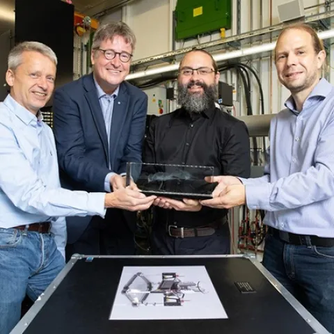 From left: Martin Müller, director of the Institute for Materials Physics at Helmholtz-Zentrum Hereon, and Christian Schroer, leading scientist of DESY's X-ray source PETRA III, accept a model of the newly identified ant from lead author Brendon Boudinot of the Friedrich Schiller University Jena, and co-author Jörg Hammel, beamline scientist at the Hereon measurement station at PETRA III, where the research took place. (Photo courtesy of Marta Meyer, DESY)