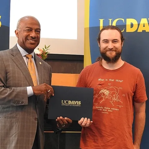 UC Davis Chancellor Gary May congratulates award recipient Brennen Dyer of the Bohart Museum of Entomology. (Photo by Kathy Keatley Garvey)