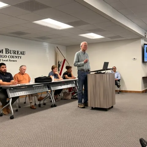 A man giving a presentation while standing behind a podium.