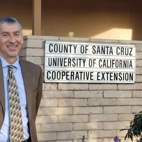 David Gonzalves poses by UC Cooperative Extension sign