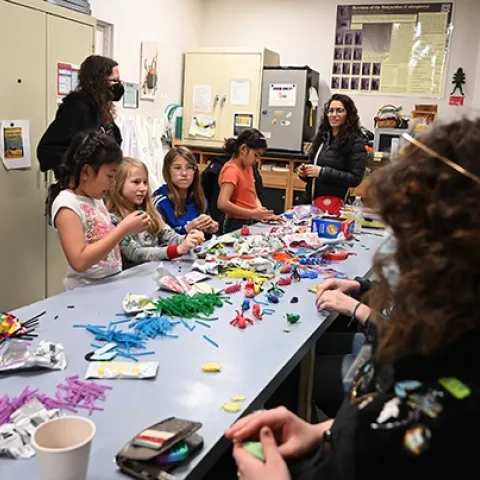 With UC Davis students (right) assisting at the Bohart Museum arts-and-crafts table, artists create arthropods and other critters, using modeling clay. (Photo by Kathy Keatley Garvey)