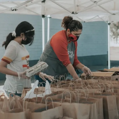 Personas recogiendo productos en un banco de alimentos