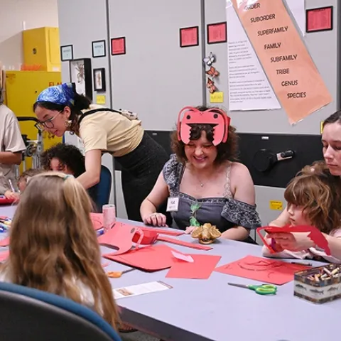 UC Davis first-year entomology student Kat Taylor (in ant headgear) staffed the arts-and-crafts table at the Bohart Museum open house. (Photo by Kathy Keatley Garvey)
