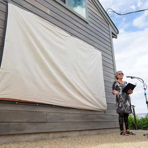 UC Davis distinguished professor Diane Ullman addresses the crowd at the Matthiasson Winery. The mural is about to be unveiled. (Photo courtesy of Jael Mackendorf, UC Davis College of Agricultural and Environmental Sciences)