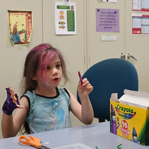 Soraya Qaqunah, 4, of Davis considers what crayons to use to make her "Mantis on a Stick." (Photo by Kathy Keatley Garvey)